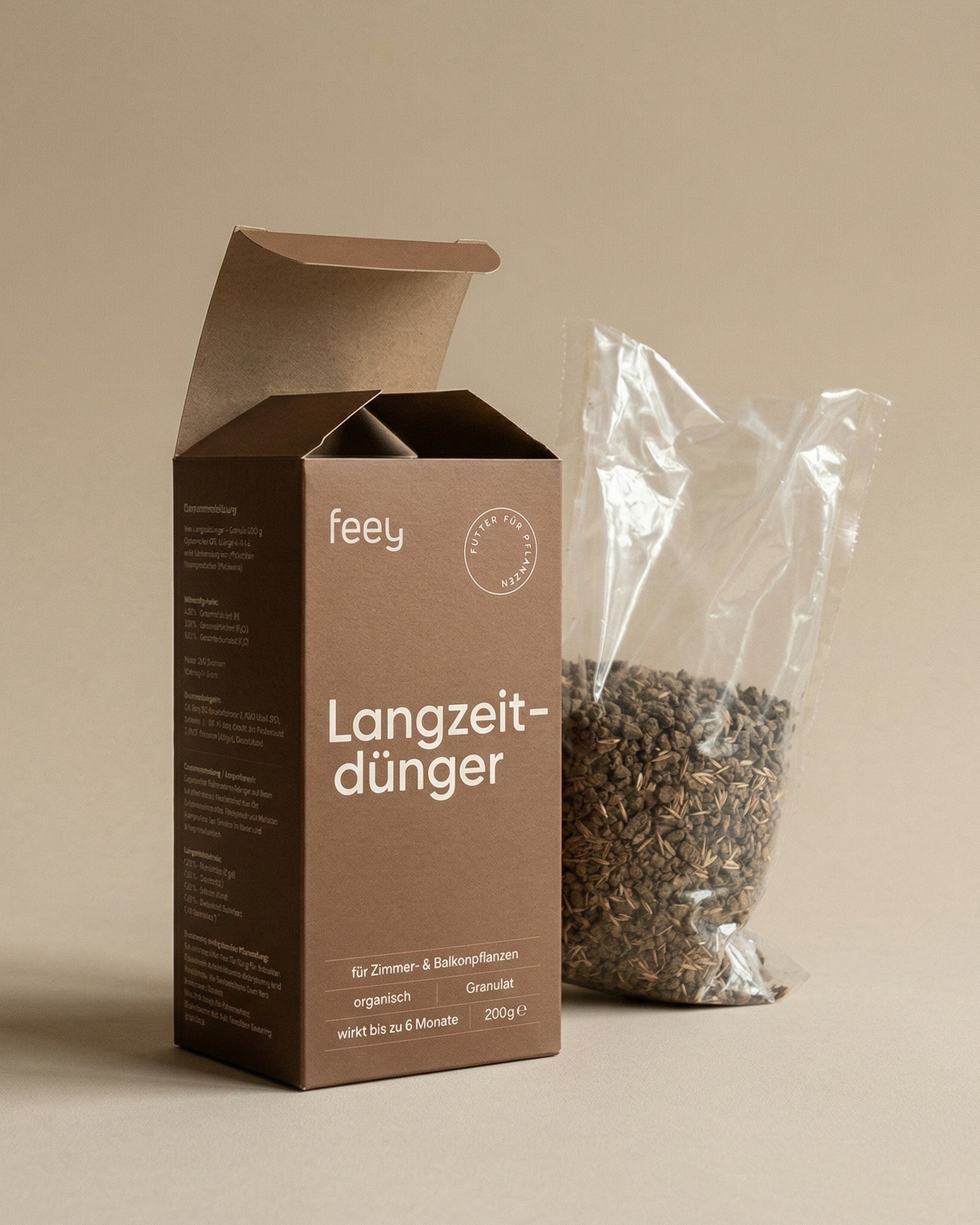Geöffnete feey Langzeitdünger-Verpackung neben einem transparenten Beutel mit organischem Dünger-Granulat
