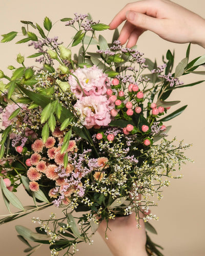 Das handgebundene Bouquet "Morgenlicht" vereint bunte Herbstblumen in Pink, Violett und Weiß mit grünen Blättern und Beeren - ein stilvoller Hingucker für dein Zuhause.
