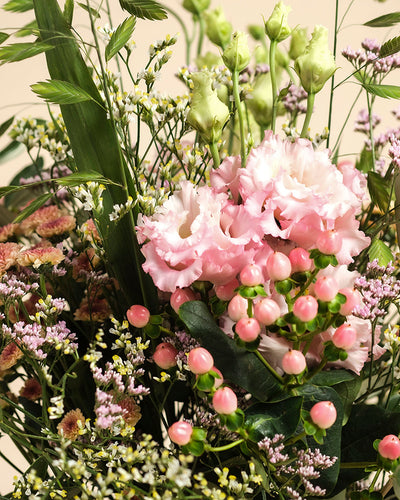 Das handgebundene Bouquet "Morgenlicht" kombiniert hell-pinke Lisianthus, pinkes Hypericum, grüne Knospen, zarte weiße und violette Herbstblumen sowie üppiges Grün und verleiht Ihrem Zuhause stilvolles Flair.