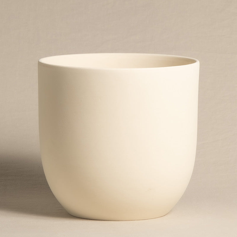 Ein einfacher, runder, cremefarbener Keramiktopf mit glatter, matter Oberfläche. Dieser schicke Keramik-Topf (Direito | 22 cm ⌀) hat ein minimalistisches Design und eine leicht konische Form auf einem neutral gefärbten Hintergrund.