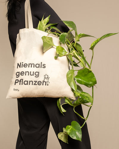 Frau trägt eine Stofftasche mit dem Aufdruck «Niemals genug Pflanzen» um die Schulter