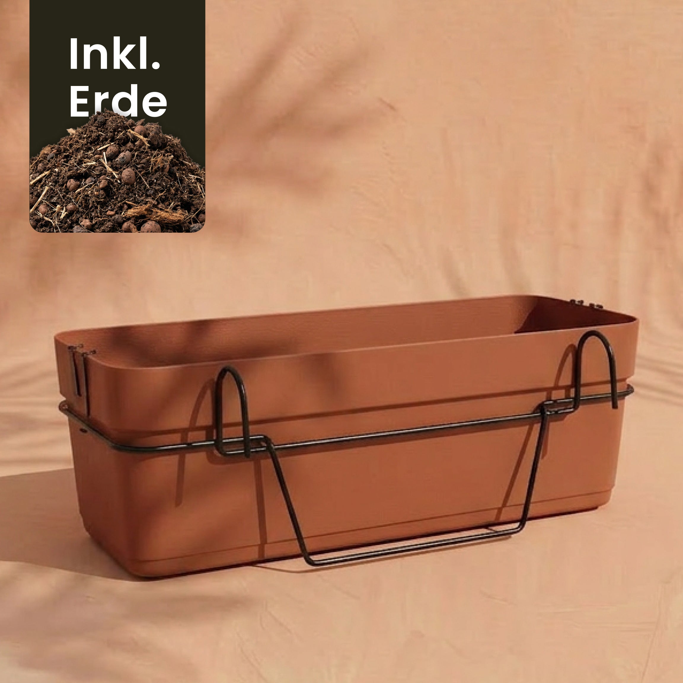 Der Pflanzkasten für Geländer (Blossom | 60 cm) ist mit einem schwarzen Metallhalter auf beigem Hintergrund abgebildet, ideal für Ihren Balkon. Ein Einsatz mit der Aufschrift 