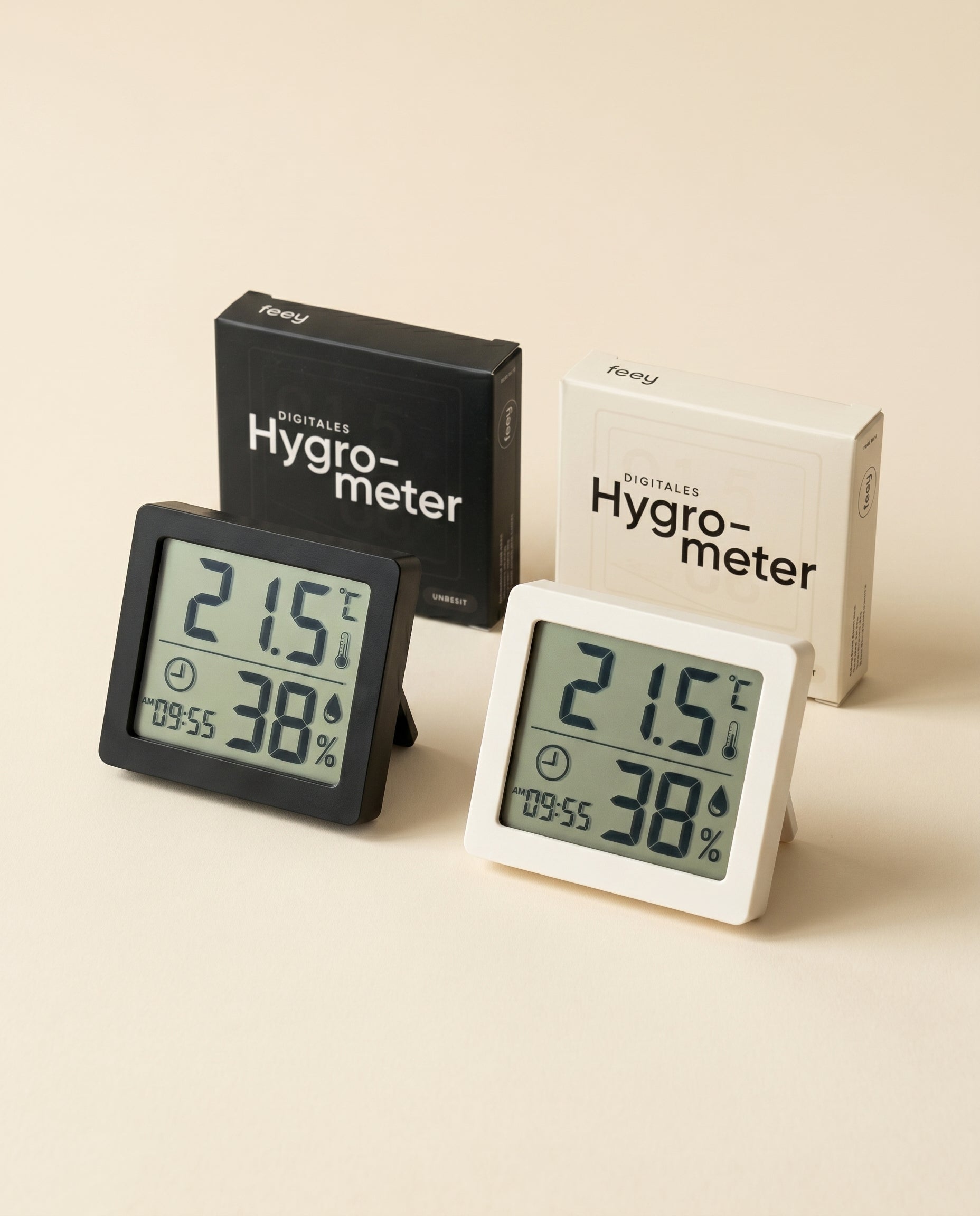 Zwei Hygrometer (schwarz und weiß) zeigen Temperatur (21,5°C) und Luftfeuchtigkeit (38%) an, jedes vor seinem Kasten auf einer beigen Fläche - perfekt für die Überwachung von Zimmerpflanzen.