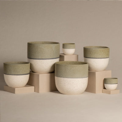 Das Keramik-Topfset „Variado“ (2 × 18, 2 × 14, 2 × 7) besteht aus handgefertigten Keramik-Pflanzgefäßen in verschiedenen Größen mit strukturierter grüner Oberseite und glatter cremefarbener Unterseite, angeordnet auf beigen Blöcken vor einem minimalistischen, neutralen Hintergrund.