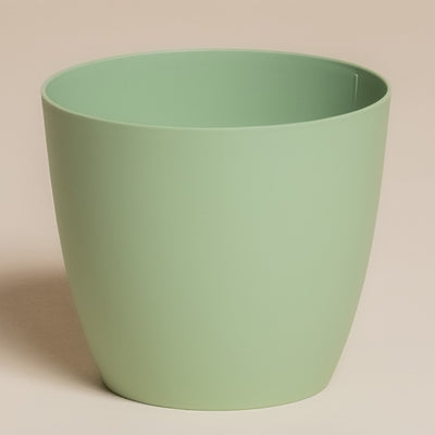 Der Kunststoff-Topf (Kiki | 11 cm Ø) in Hellgrün hat ein glattes, zylindrisches Design und steht auf einem beigen Hintergrund - ideal für dezente Zuhause Deko in jedem Raum.