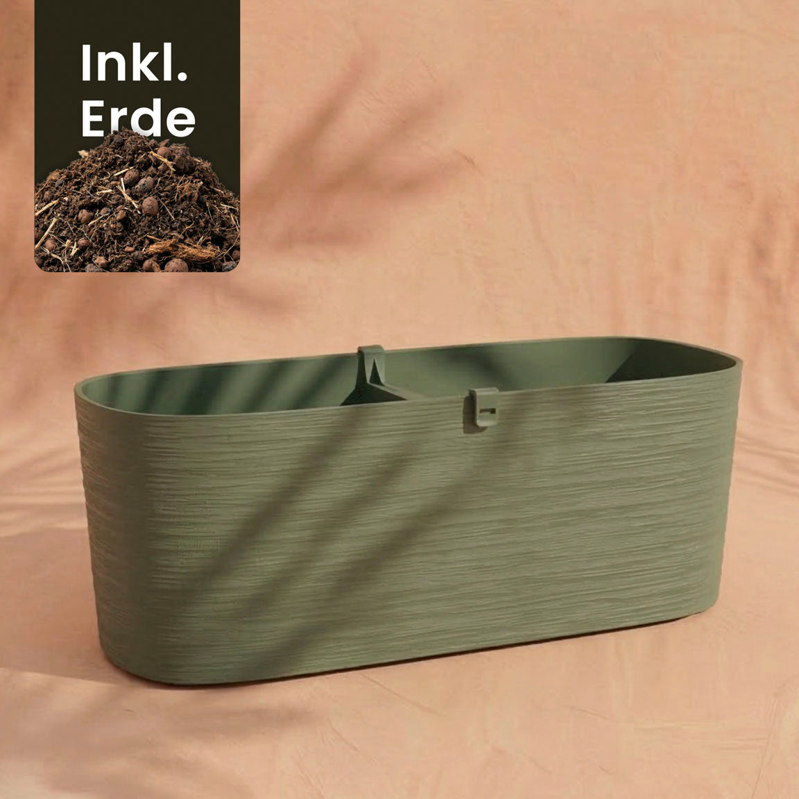 Ein grün strukturierter Pflanzkasten (Paros | 60 cm) ruht auf einer pfirsichfarbenen Oberfläche. Ein Einsatz oben links zeigt Erde mit dem Text 