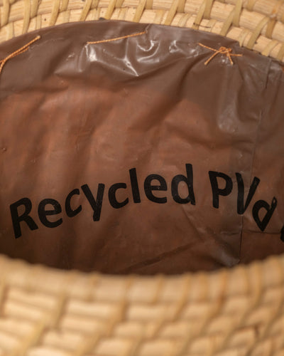 Draufsicht auf den Pflanzenkorb aus Rattan (Calen | 22 cm Ø) mit braunem Innenfutter aus recyceltem PVC. Die handgeflochtene, naturfarbene Rattan-Außenseite macht diesen Korb zu einer stilvollen Ergänzung für jeden Raum.