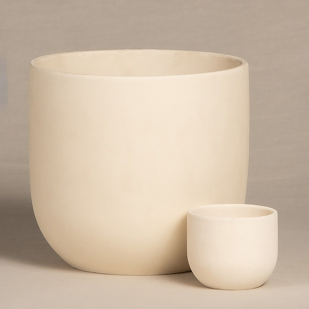 Vor einem neutralen Hintergrund sind zwei minimalistische beigefarbene Keramik-Pflanzgefäße zu sehen, die sorgfältig von Hand gefertigt wurden. Das größere Gefäß ist zylindrisch und hat eine glatte Oberfläche, während das kleinere Gefäß davor ein ähnliches Design aufweist. Beide Keramik-Topfsets „Direito“ (18, 7) haben eine moderne, schlichte Ästhetik mit einem subtilen Hauch von Handwerkskunst.