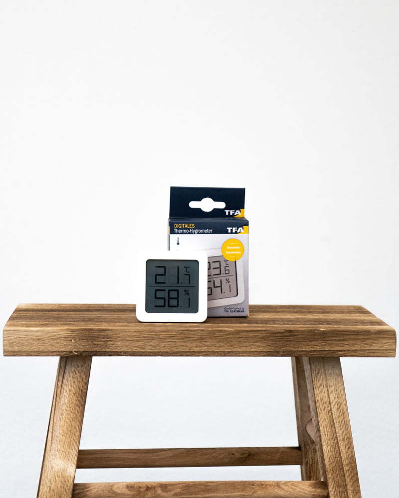 Hygrometer weiss vor seiner Verpackung auf einem Holztisch