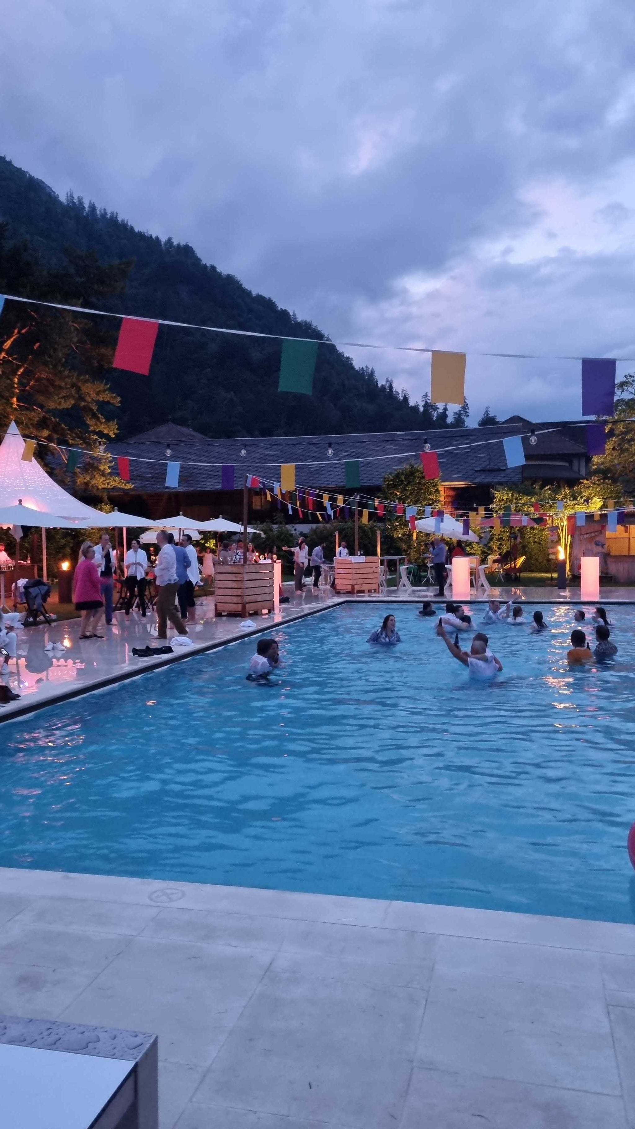 Poolparty mit vielen Personen im Wasser und neben dem grossen Wasserbecken.
