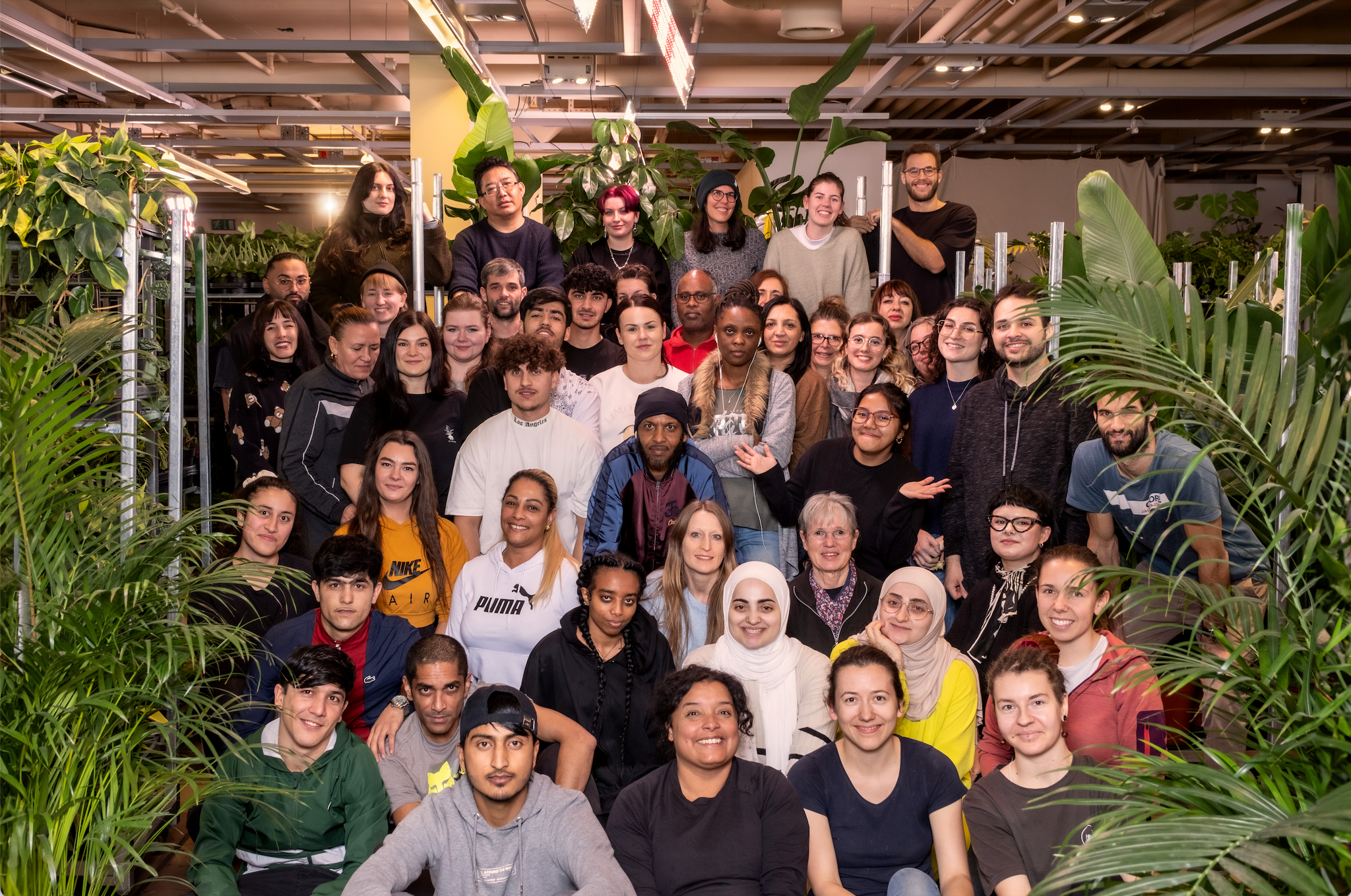 Gruppenfoto mit 48 Personen umgeben von Zimmerpflanzen.