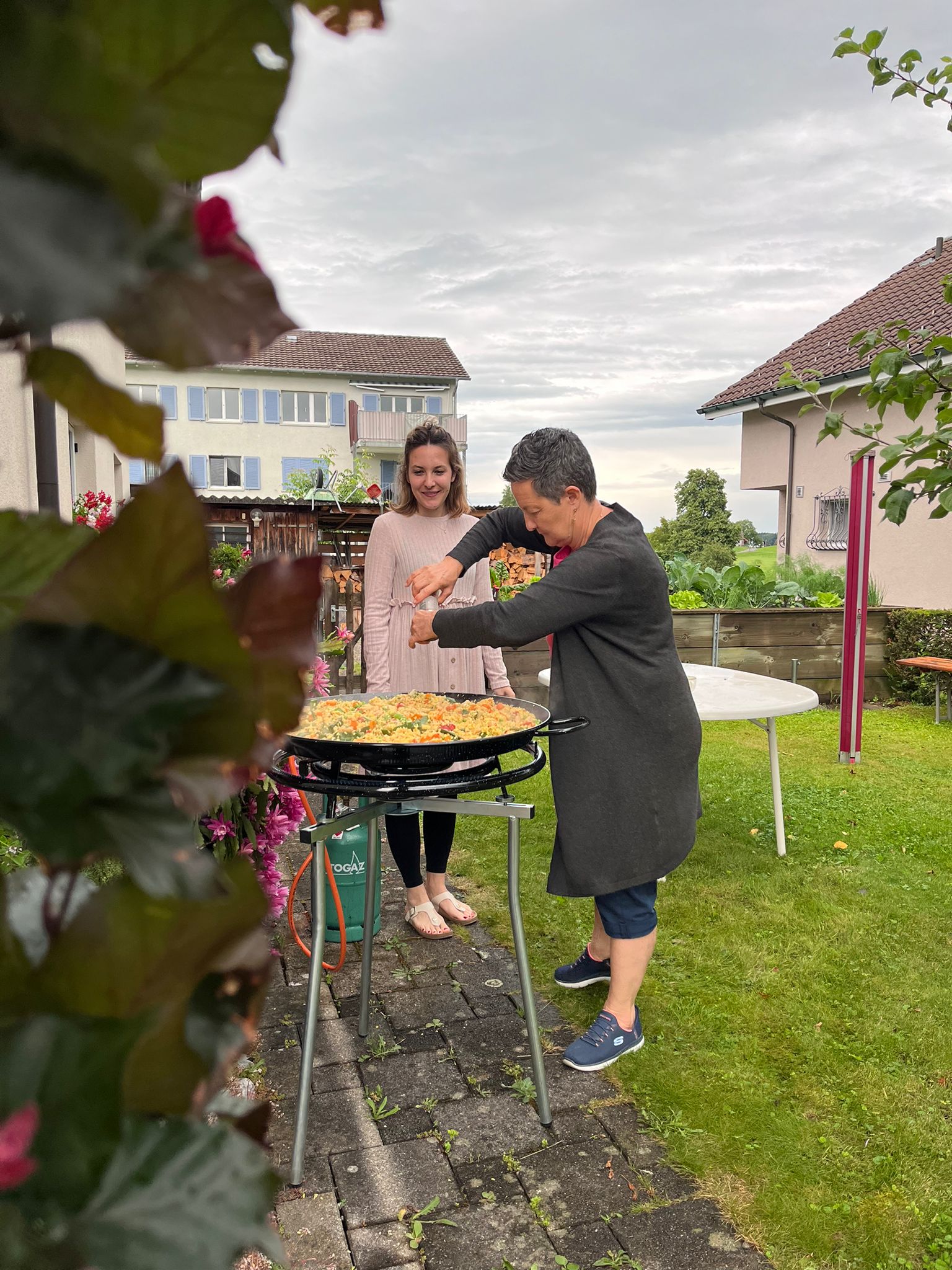 Zwei Frauen stehen vor einer riesigen Paella-Pfanne.