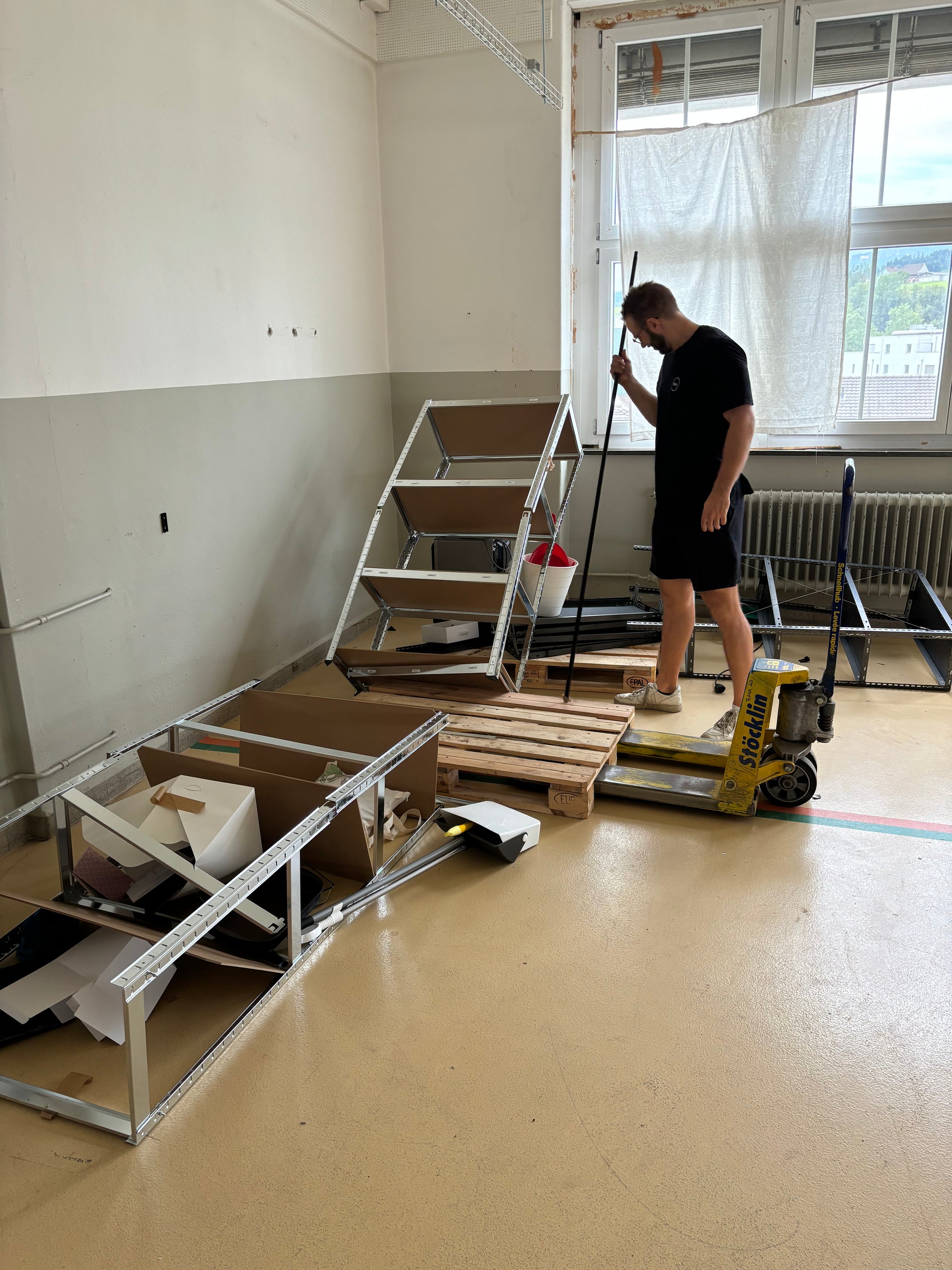Eine Person steht vor zwei umgestürzen Regalen.