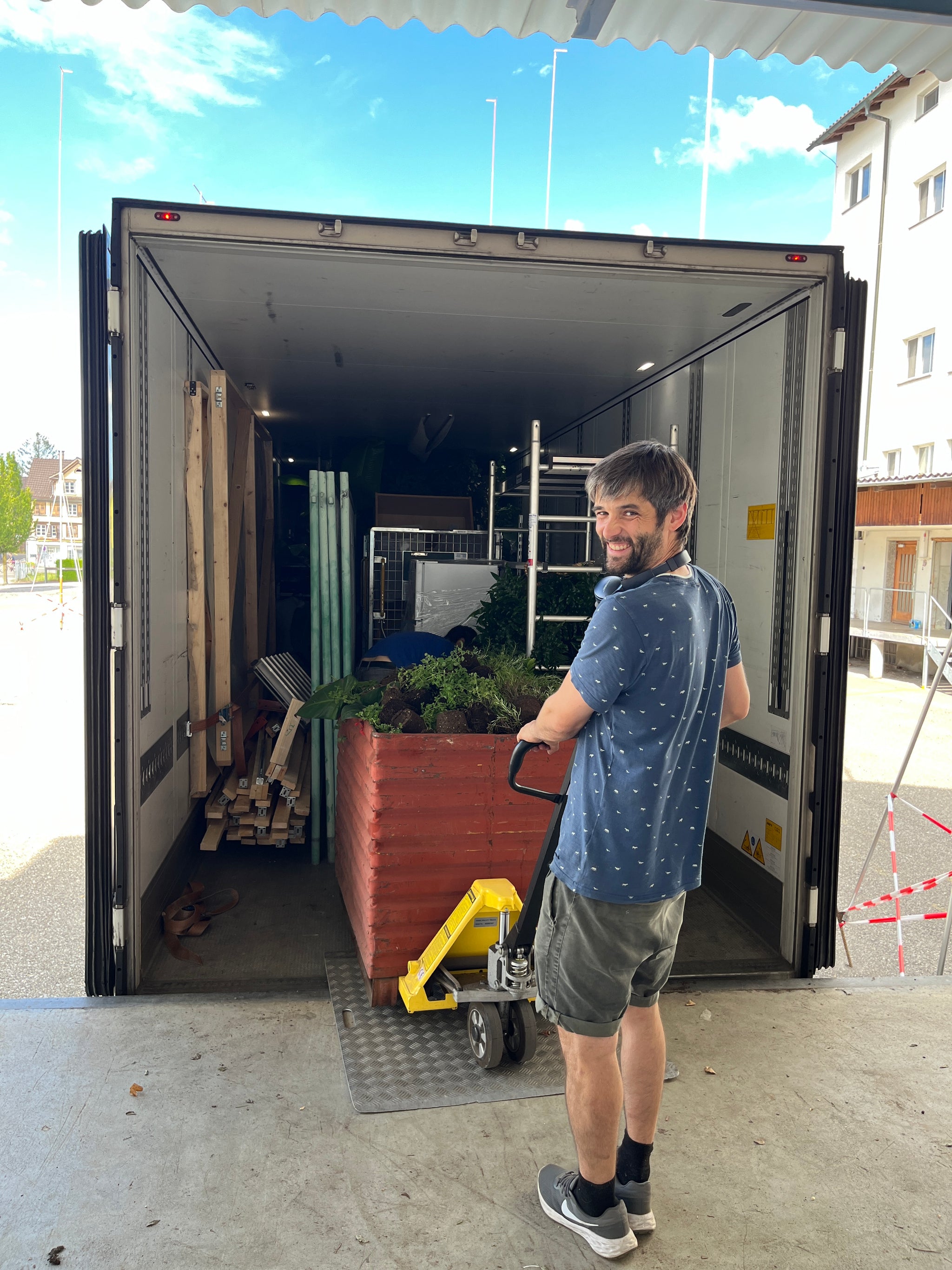 Eine Person beladet einen Lastwagen mit Hubwagen.