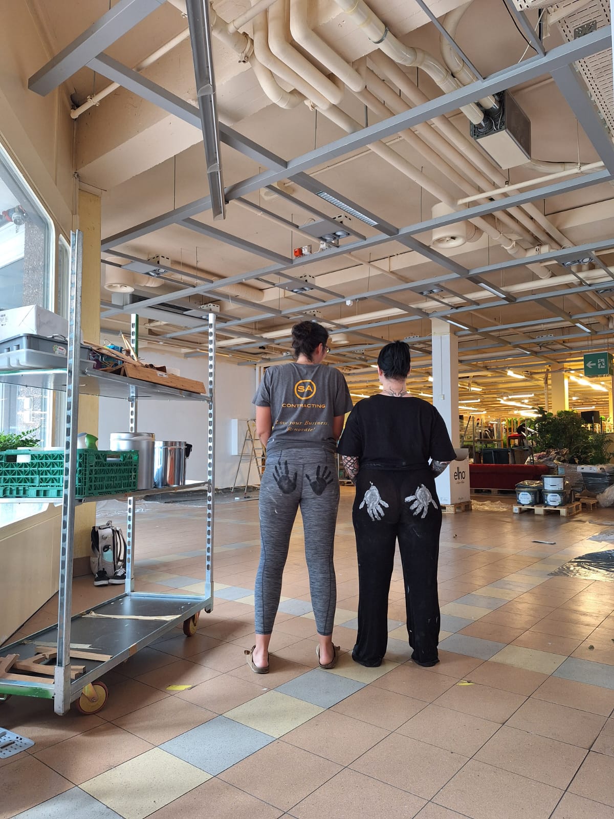Zwei Frauen von hinten mit Handabdrücke auf ihren Hinterteilen.