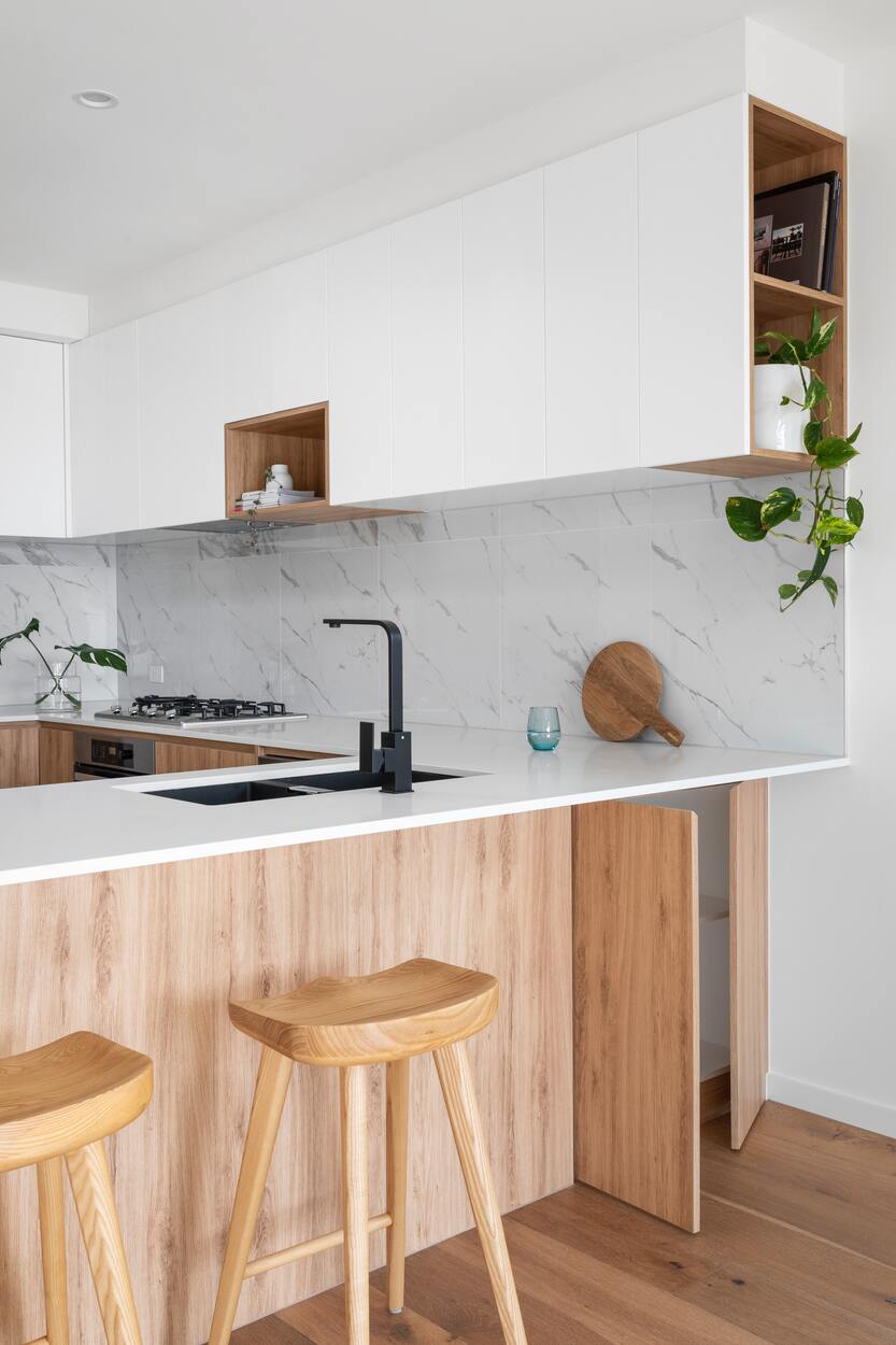 Holzküche mit marmorener Rückwand und Efeutute im einen offenen Küchenregal 