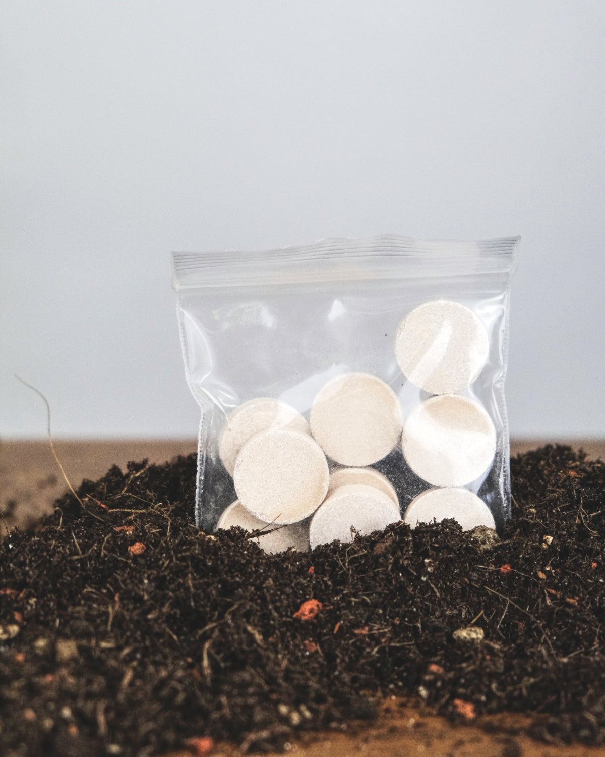 Solbac-Tabs in kleinem Plastiksäckchen in einem Erdenhaufen