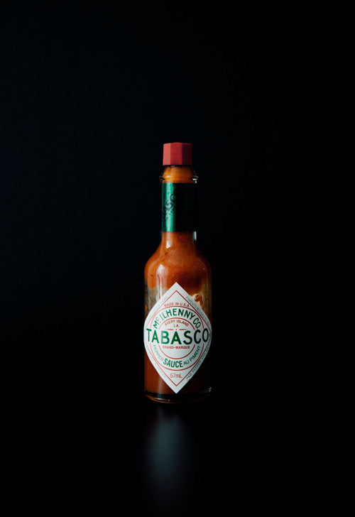 Tabasco-Flasche vor schwarzem Hintergrund
