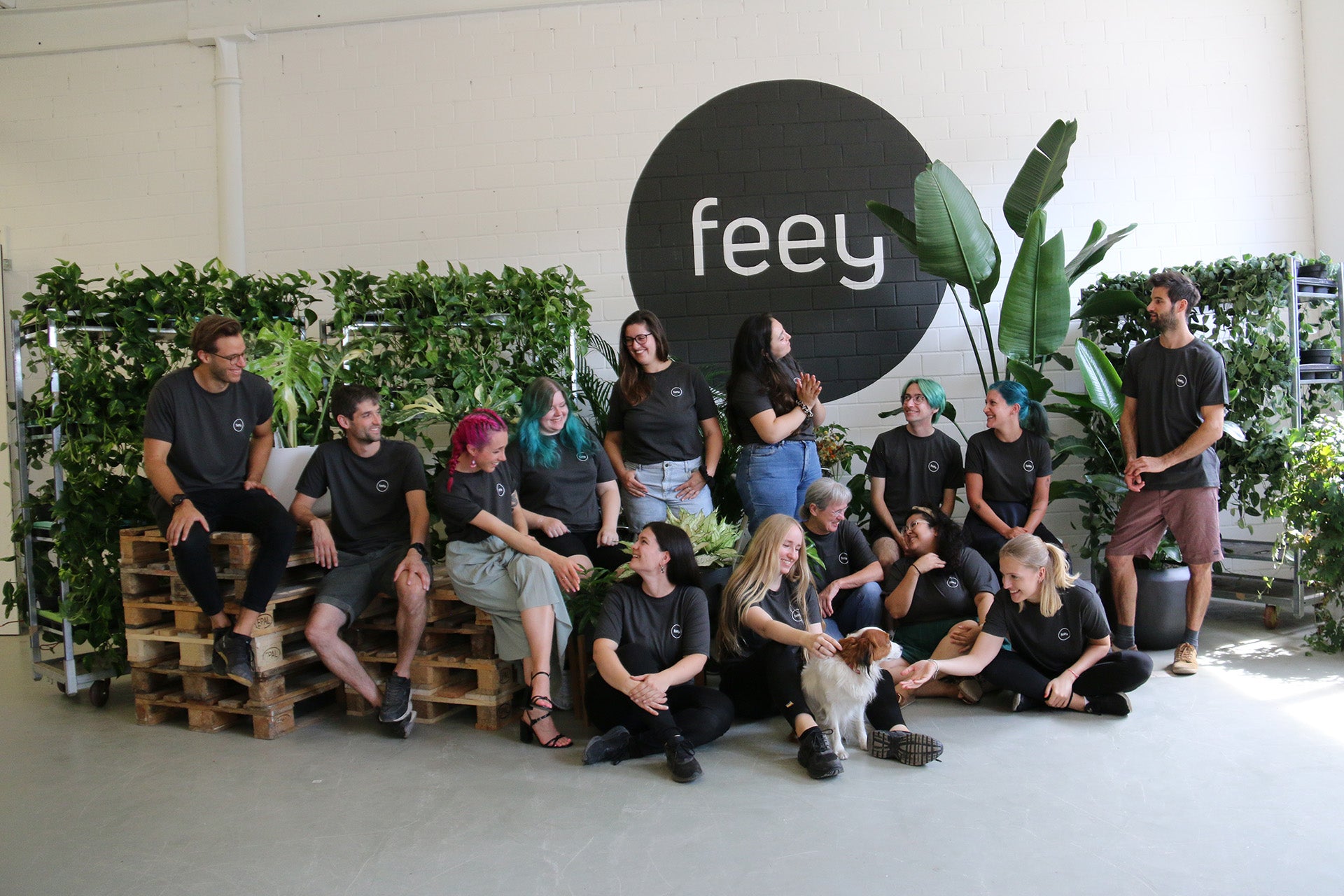 Gruppenfoto von feey vor Logo mit Pflanzen.